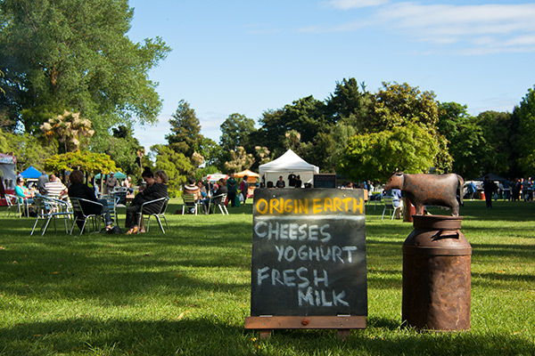 People sitting on the grass enjoying locally made dairy products